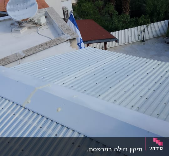 אדם משתמש באקדח סיליקון על גג מתכת